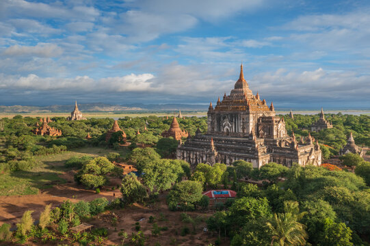Aerial view of the ancient Sulamani Temple and surrounding pagodas nestled in lush greenery under a cloudy sky in Old Bagan, Mandalay Region, Myanmar Burma.