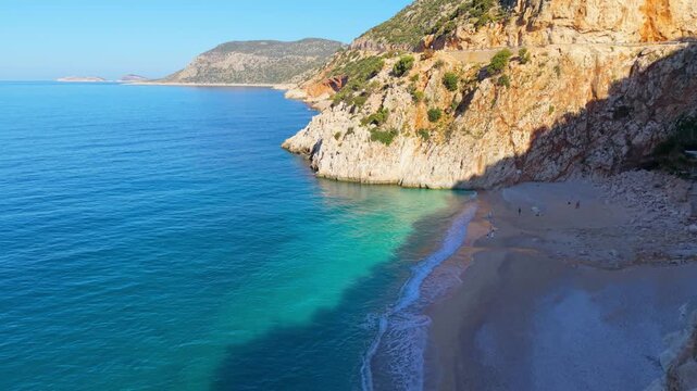 A couple of men and women at Kaputas Beach Kas, Turkey, where crystal clear waters meet majestic cliffs. Experience the serene beach and captivating natural beauty in this coastal paradise.