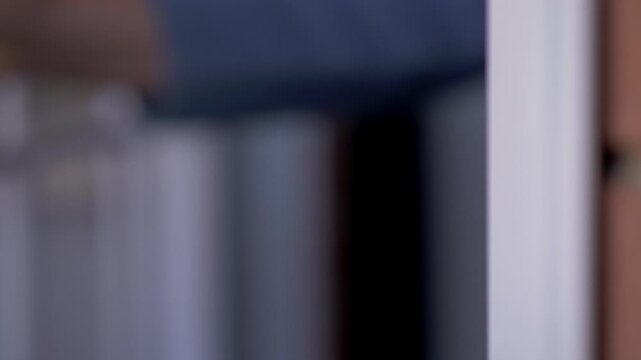 Woman hands insert a key into the metal gate of a house door to unlock it. The scene highlights security, routine, and residential daily life.