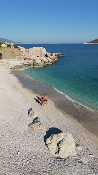 Discover the idyllic shores of Kas, Turkey, featuring crystal-clear waters and smooth pebbled beaches. Visitors can stroll along the coastline, soaking in the tranquil beauty of this hidden gem.