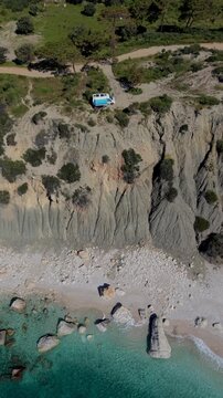 Stunning cliffs and pristine beach in Kas, Turkey, showcasing crystal-clear waters. Experience the tranquility and natural beauty, camping in a camper van or motorhome at the seaside on a cliff