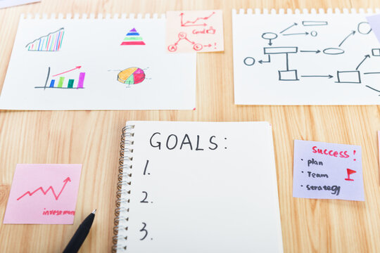 There is a blank book with goals and some charts on the desktop.