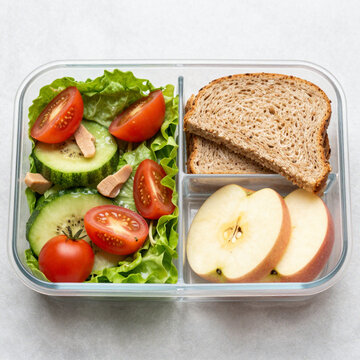 Healthy Packed Lunch in a Glass Meal Prep Container with Fresh Salad Whole Grain Bread and Apple Slices