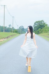 Fototapeta premium Elegant Woman Walking on Empty Road in Khao Yai, Thailand