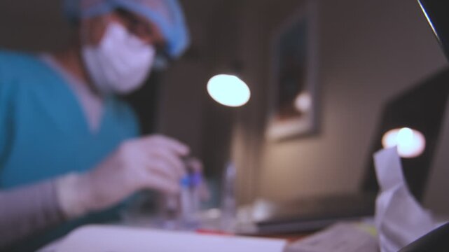 Medical professional in a lab carefully examining a test tube containing a blood sample