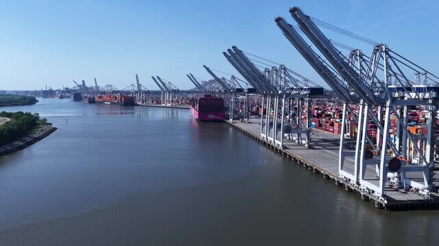 Commercial Shipping Terminal in Savannah Georgia Ports Authority with cranes and containers on Savannah River in Morning sunlight