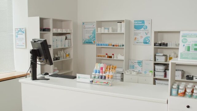 Wide angle shot of clean white pharmacy interior with checkout counter and shelves filled with medication bottles and tablet packs, background with copy space