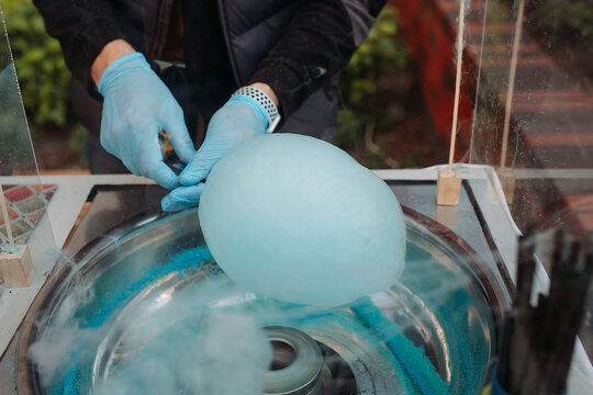 Man making cotton candy with machine outdoors, closeup