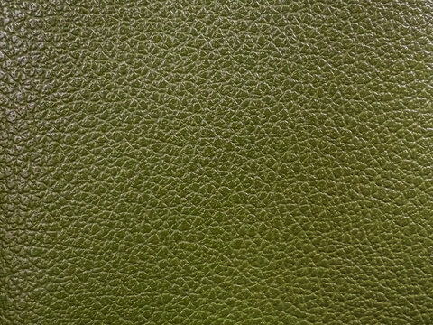 Macro close-up of olive green pebble grain leather texture, perfect for backgrounds in fashion design, luxury upholstery, and product mockups highlighting durable material detail and quality.