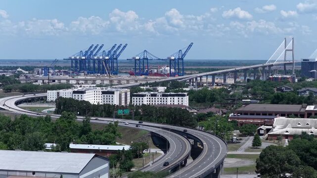 Highway travel into Savannah, Georgia with suspension bridge over Savannah River and Georgia Ports Authority in distance