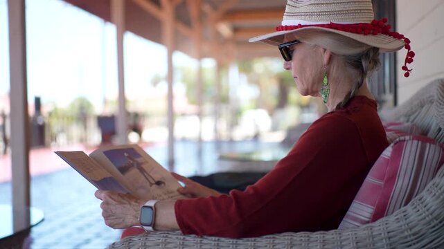 A woman enjoys her time in Santa Rosalia, Baja California Sur while looking at a guidebook and taking in the local culture near the sea.