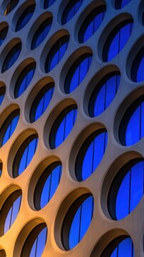 A close-up view of a modern building facade featuring an array of circular window designs