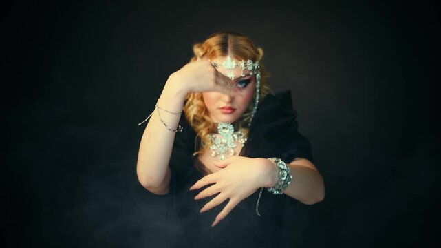 Fantasy mystery girl dark queen woman beauty face waving with hads dancing, luxury elf girl, black dress hood blonde hair royal person fashion model posing silver jewelry victorian style. long nails 