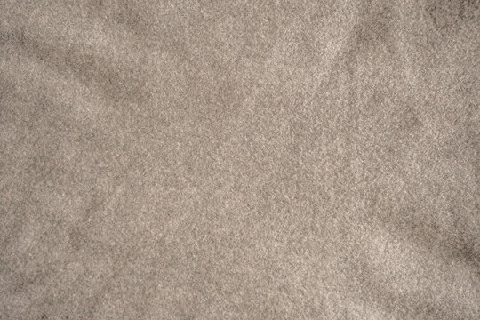 Natural texture of a beige wool fabric. Soft woven cotton texture. Perfect for a decorative background. Close-up. Top view.