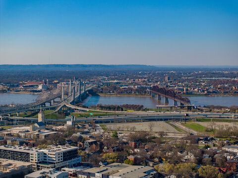 Aerial view of the Abraham Lincoln Bridge and Big Four Bridge crossing the Ohio River with the urban landscape and highways in Louisville, Kentucky, United States.
