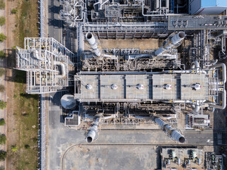 Fototapeta premium Top-down aerial view of complex industrial pipelines and chimney stacks at a modern power plant or factory.