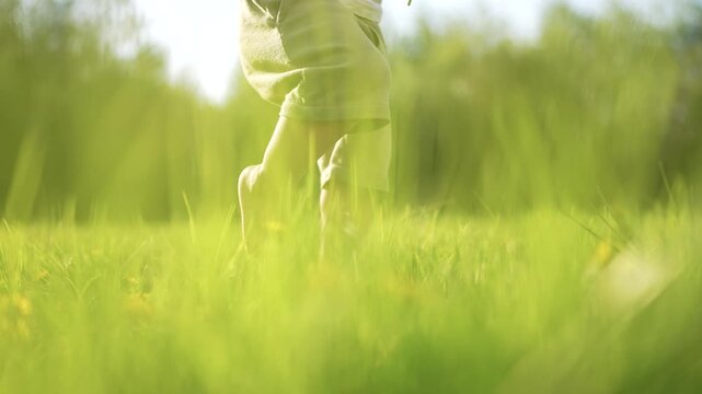 Child's bare feet running through a field. Baby steps in the grass at the park. A child is walking on bare feet. A lifestyle child's unshod feet dashing across a meadow.