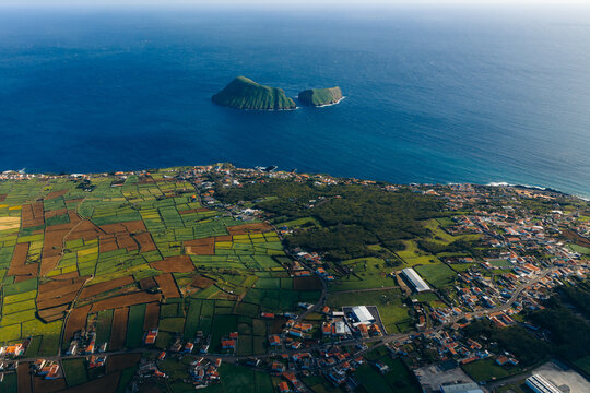 Aerial view of Pico Dona Joana geodesico overlooking the patchwork fields and the coastline with the Ilheus das Cabras islets in the distance Feteira, Acores, Portugal.