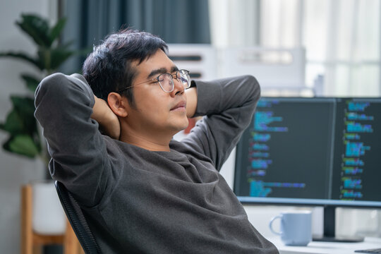 Relaxing programmer takes a break at home office indoor setting computer science focus calm atmosphere introspective view