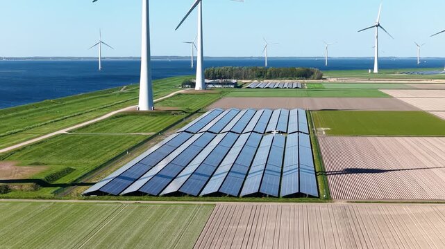 Aerial drone view of solar panels and wind turbines in a renewable energy farm. Sustainable green power station for clean electricity production and environmental technology infrastructure.