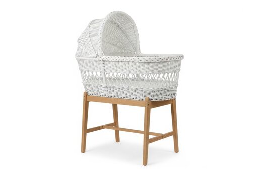 A beautifully crafted white woven baby bassinet with wooden legs.