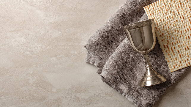 Passover matzah and kiddush cup on a towel with passover religious traditional ceremony