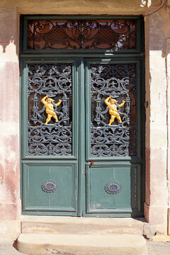 Porte avec grilles et 2 anges avec leur serpent