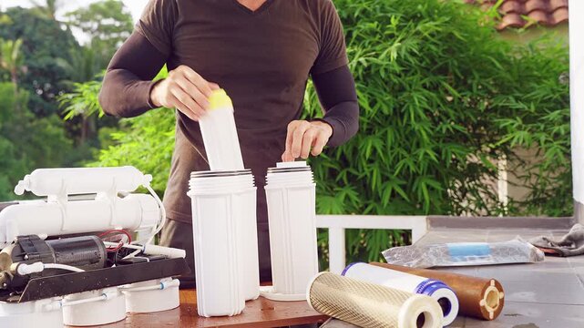 Close Up Installation of Carbon Water Filter Cartridge Into Reverse Osmosis Purification System Outdoors, Clean Drinking Water and Household Service