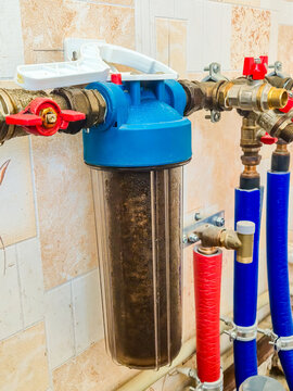 Dirty sediment filter on apartment water supply system with red valves