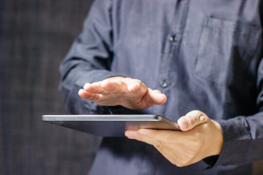 Man using digital tablet with hand hovering over screen. Business communication. Business and Technology Concept. High quality photo