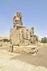 Obraz premium The Colossi of Memnon two massive stone statues of the Pharaoh Amenhotep III, which stand at the front of the ruined Mortuary Temple of Amenhotep III