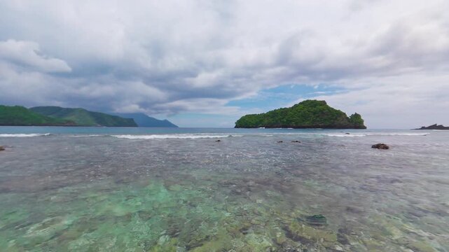 Masare Island, Sitaro Regency, North Sulawesi, Indonesia, featuring the view from the shore over crystal clear ocean water and tropical greenery.