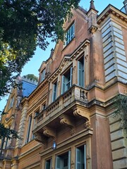 Obraz premium Elegant historic building facade with trees and blue sky
