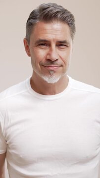 Portrait of happy casual older man smiling, Mid adult, mature age guy with gray hair, Isolated on white background, copy space.