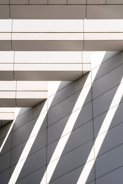 white panels and shadow bands turn geometric architecture into a measured facade, where exterior structure, light, urban lines and cladding recede.