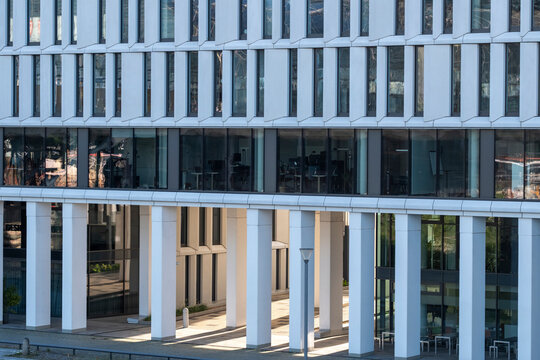blue glass windows repeat through urban architecture, letting reflection and symmetry align the facade, columns, exterior grid and structure.