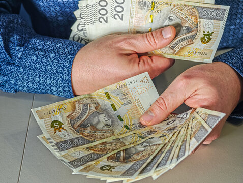Man holding fan of 200 Polish Zloty banknotes PLN currency, financial success and wealth concept