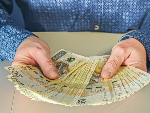 Man holding fan of 200 Polish Zloty banknotes PLN currency, financial success and wealth concept