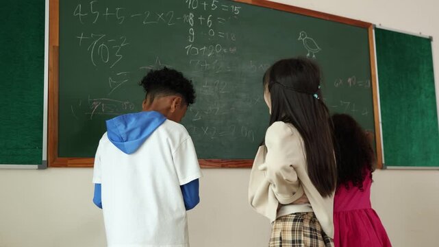 Three diverse children solving math problems on a classroom chalkboard, engaging in learning and education activities.