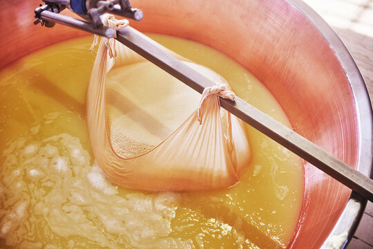 freshly formed parmesan curd from a large copper cauldron, a traditional technique used in creating Parmigiano Reggiano, Parma, Italy, Europe