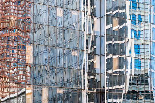 glass facade reflection folds office windows across dense urban architecture, with exterior pattern lines and blue panels stretching through depth