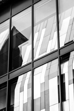 office windows cut across glass facade reflection in urban architecture, where monochrome composition shapes exterior lines with shadow and pattern