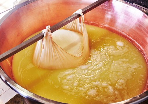 freshly formed parmesan curd from a large copper cauldron, a traditional technique used in creating Parmigiano Reggiano, Parma, Italy, Europe