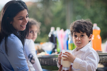 Obraz premium Modern Middle Eastern family enjoying Ramadan iftar dinner together with children and milk