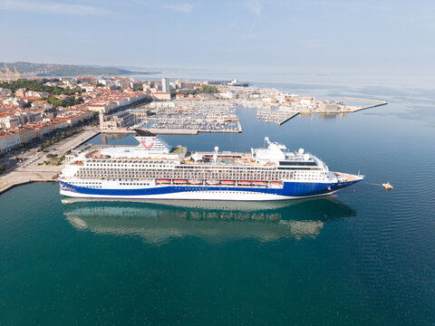 TRIESTE, ITALIA - 9 MAGGIO 2026: Veduta aerea della nave da crociera Marella Explorer 2 ormeggiata alla Stazione Marittima con lo sfondo del panorama cittadino 