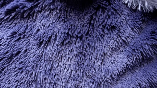 Fluffy blue faux fur texture blowing in the wind. Abstract background. Shaggy fabric with long soft fibers