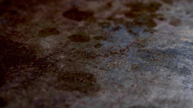 Dark burned oven tray texture with rusty stains and greasy cooking marks. Abstract industrial metal background featuring scorched surface