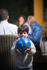 Obraz premium Middle Eastern family celebrating Eid Ramadan iftar with young boy holding a soccer ball at modern home