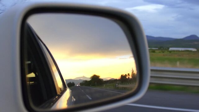 Cinematic road trip footage showing sunset reflection in vehicle side-view mirror