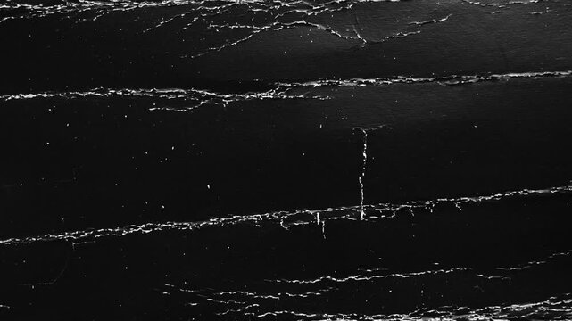 Cracked black cardboard texture. Abstract torn paper background with deep horizontal tears and white fiber scratches. Dark monochrome grunge surface. Rotation